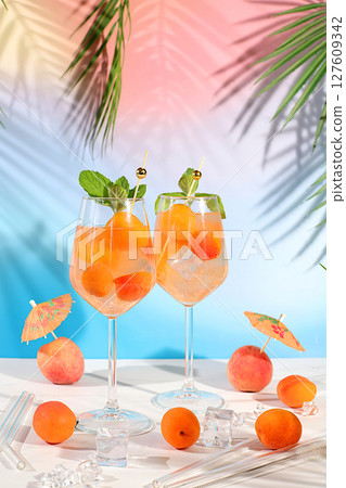 Modern still life with fruits. Royal lemonade cocktail with peach, apricot, mojito with tequila, gin, rum, ice and fresh mint, bar and party concept, restaurant and cafe advertising card 127609342