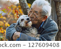 A warm moment for an elderly man smiling while holding a dog A warm moment for an elderly man smiling while holding a dog 127609408