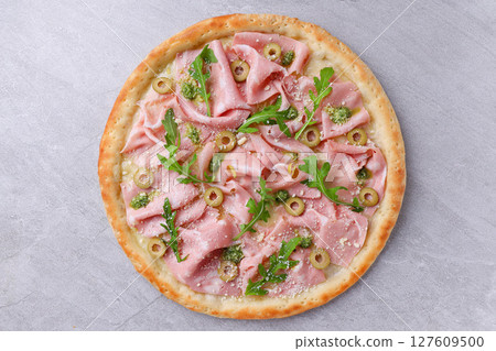 Rustic Mortadella Olive Pesto Pizza with Fresh Arugula Garnish 127609500