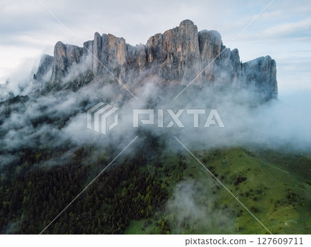 Aerial view of rocky mount Bolshoy Tkhach with clouds in Caucasus mountains Aerial view of rocky mount Bolshoy Tkhach with clouds in Caucasus mountains 127609711