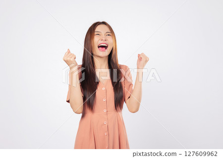 Success empowered by success she celebrates her moment with a raised fist and a bright excited smile showing confidence and professional victory isolated studio white background Success empowered by success she celebrates her moment with a raised fist and a bright excited smile showing confidence and professional victory isolated studio white background 127609962