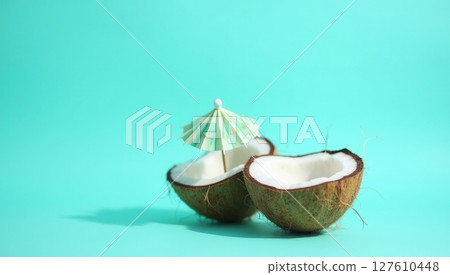 Half coconut shell on turquoise background 127610448