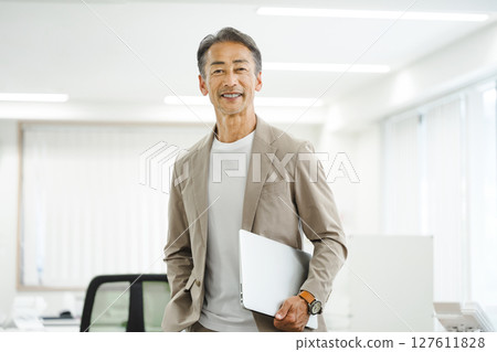 一位 60 多歲的老人在辦公室工作 一位 60 多歲的老人在辦公室工作 127611828