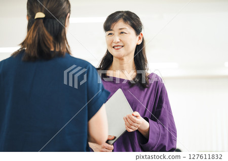 A career woman in her 50s having a fun conversation with her colleagues 127611832