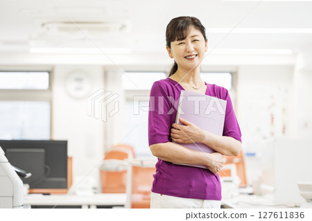Portrait of a woman in her 50s working in an office Portrait of a woman in her 50s working in an office 127611836