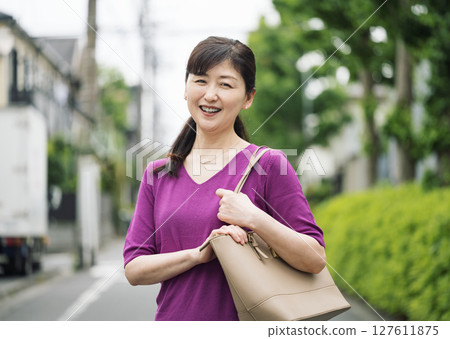 Outdoor portrait of a middle-aged woman in her 50s going to work 127611875
