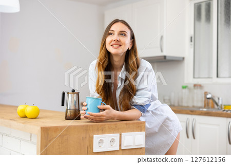 Portrait of attractive woman drinking coffee at home Portrait of attractive woman drinking coffee at home 127612156