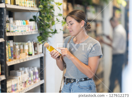 Young woman selecting natural beauty products in eco store Young woman selecting natural beauty products in eco store 127612273