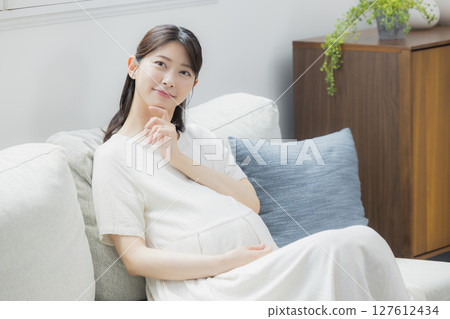 pregnant woman in the living room pregnant woman in the living room 127612434