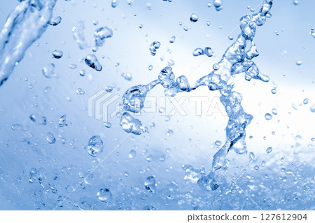 Water splashes on a blue background. 127612904