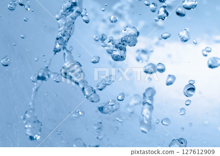 Water splashes on a blue background. 127612909