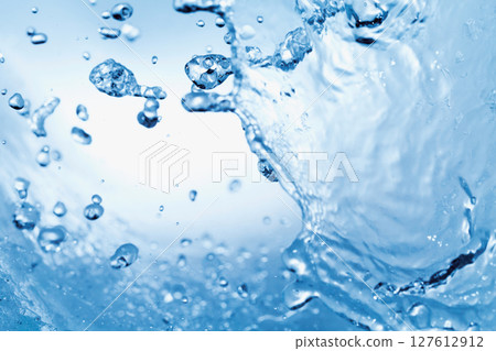 水濺在藍色背景上。 127612912