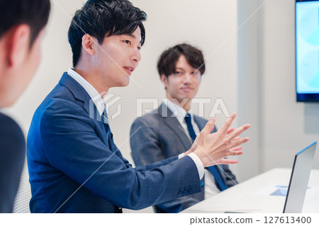 A young male businessman speaking at a meeting 127613400