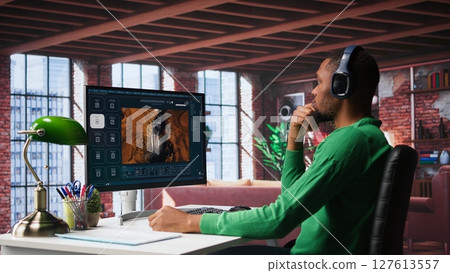 African american guy exploring generative AI art and deep learning visuals on a monitor. Uses predictive technology, virtual assistants and programs to bring prompts to life. Camera B. African american guy exploring generative AI art and deep learning visuals on a monitor. Uses predictive technology, virtual assistants and programs to bring prompts to life. Camera B. 127613557