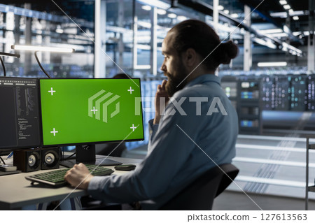 Technician using green screen mockup PC in data center to update servers tech, configuring equipment using software tools. Server room employee reviewing hardware analytics on chroma key PC 127613563