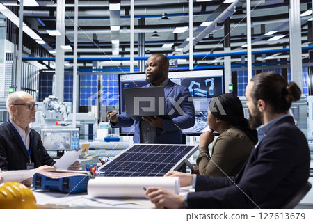 Investor presents sustainable manufacturing solutions to factory executives. Man doing pitch for innovative solar panel production automation technologies to industrial plant management executives 127613679