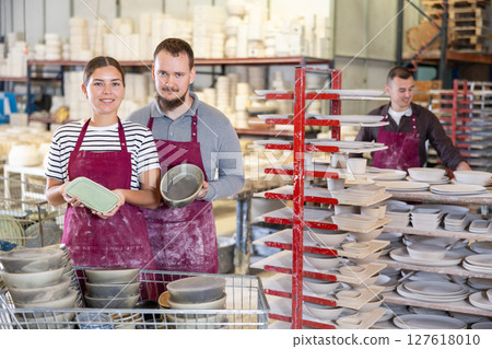 Man and woman posing with ceramic dishes Man and woman posing with ceramic dishes 127618010
