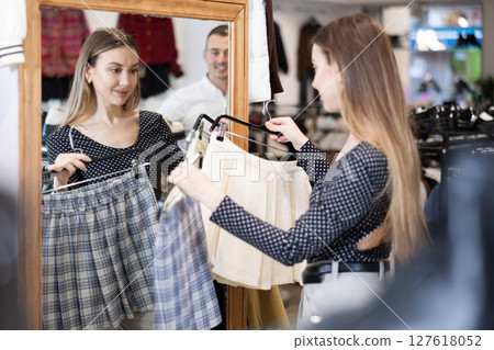Couple young woman and young man choosing skirt 127618052