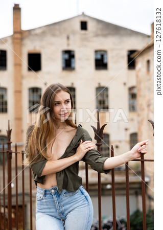 Outdoor fashion - beautiful blonde woman posing near wrought iron fence Outdoor fashion - beautiful blonde woman posing near wrought iron fence 127618132