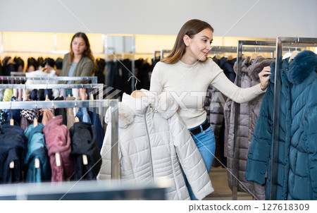 Young woman choosing insulated coat in store Young woman choosing insulated coat in store 127618309