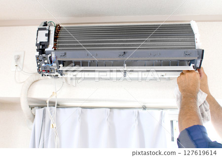 The hands of a worker inspecting a residential air conditioner The hands of a worker inspecting a residential air conditioner 127619614