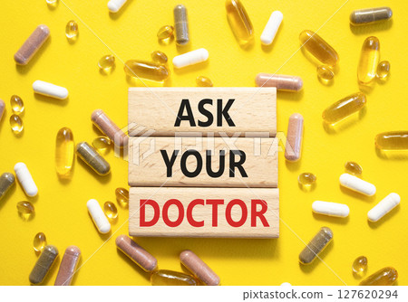Ask Your Doctor symbol. Concept word Ask Your Doctor on wooden blocks. Beautiful yellow background with pills. Medicine and Ask Your Doctor concept. Copy space Ask Your Doctor symbol. Concept word Ask Your Doctor on wooden blocks. Beautiful yellow background with pills. Medicine and Ask Your Doctor concept. Copy space 127620294