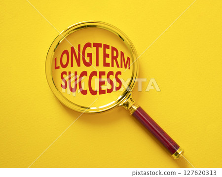 Longterm success symbol. Magnifying Glass with Concept word Longterm success. Beautiful yellow background. Business and Longterm success concept. Copy space 127620313