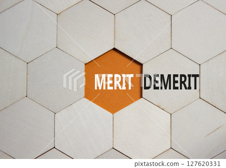 Merit or Demerit symbol. Concept word Merit or Demerit on wooden comb puzzle. Beautiful orange background. Business and Merit or Demerit concept. Copy space 127620331