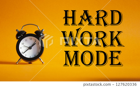 Hard Work Mode symbol. Concept word Hard Work Mode on Beautiful orange background with alarm clock. Business and Hard Work Mode concept. Copy space Hard Work Mode symbol. Concept word Hard Work Mode on Beautiful orange background with alarm clock. Business and Hard Work Mode concept. Copy space 127620336