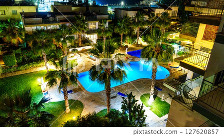 Nighttime Oasis Illuminated Resort Pool with Palm Trees Under Starry Sky, Vacation Getaway Nighttime Oasis Illuminated Resort Pool with Palm Trees Under Starry Sky, Vacation Getaway 127620857
