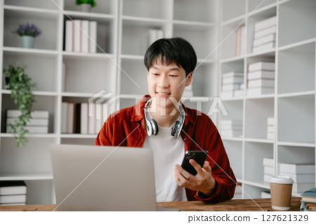 Happy asian business man have the joy of talking on the smartphone, tablet and laptopon the office 127621329