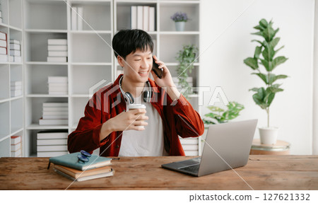 Happy asian business man have the joy of talking on the smartphone, tablet and laptopon the office Happy asian business man have the joy of talking on the smartphone, tablet and laptopon the office 127621332