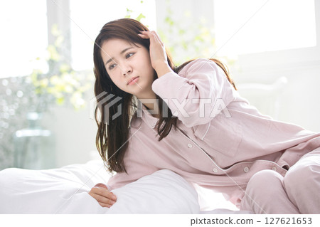 Young woman relaxing in pajamas Young woman relaxing in pajamas 127621653