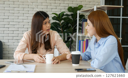 Two pretty best friends forever girlfriend talk, hug and laugh together sitting on sofa in cozy home relax. Happy friendship smile talking together positive emotion in living room joyful lifestyles 127621660