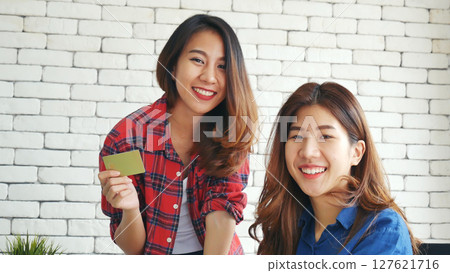 Two friends shopping using credit card online shopping on website laptop e-commerce website with smiling face, happiness. Happy asian women using laptop shopping online buy, payment newnormal concept Two friends shopping using credit card online shopping on website laptop e-commerce website with smiling face, happiness. Happy asian women using laptop shopping online buy, payment newnormal concept 127621716