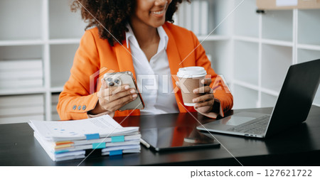 Successful African Businesswoman Analyzing Finance on Tablet and Laptop at modern Office Desk tax, Successful African Businesswoman Analyzing Finance on Tablet and Laptop at modern Office Desk tax, 127621722