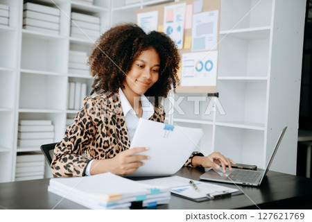 Successful African Businesswoman Analyzing Finance on Tablet and Laptop at modern Office Desk tax, Successful African Businesswoman Analyzing Finance on Tablet and Laptop at modern Office Desk tax, 127621769