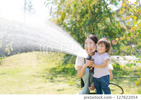 Parents and children watering the garden 127622054