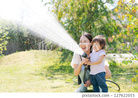 Parents and children watering the garden Parents and children watering the garden 127622055