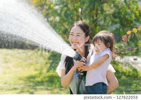 Parents and children watering the garden 127622058