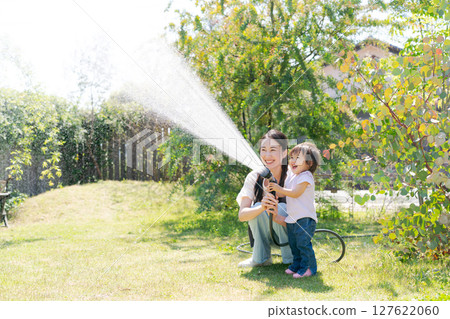 Parents and children watering the garden 127622060