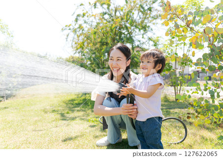 父母和孩子在花園澆水 父母和孩子在花園澆水 127622065