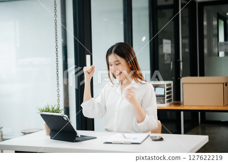 business woman are delighted and happy with the work they do on their tablet, laptop and taking notes at the office. 127622219