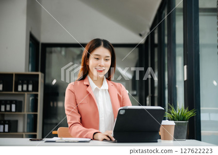 Asian businesswoman working in the office with working notepad, tablet and laptop documents 127622223