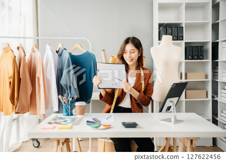 Diverse female fashion designers at work with tailor centimeters on necks and holds tablet and smartphone. independent creative design Diverse female fashion designers at work with tailor centimeters on necks and holds tablet and smartphone. independent creative design 127622456