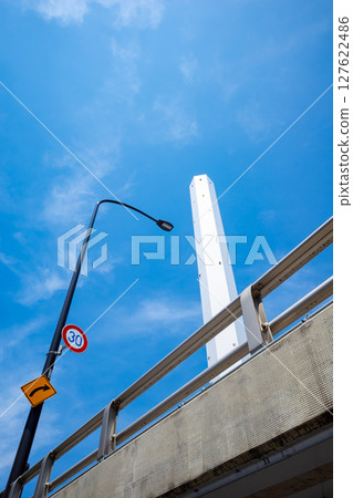 Looking up at street lights and tall chimneys a-1 127622486