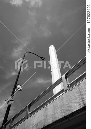 Looking up at street lights and tall chimneys a-6 monochrome 127622491