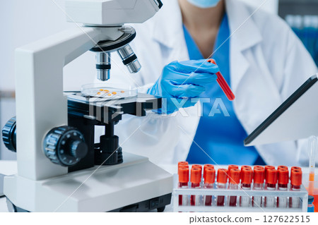 Modern medical research laboratory. female scientist working with micro pipettes analyzing biochemical samples, advanced science chemical laboratory 127622515