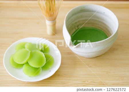 Cup of fresh matcha tea, green tea and Steamed Pandan Layer Cake, Thailand dessert on wooden table. Cup of fresh matcha tea, green tea and Steamed Pandan Layer Cake, Thailand dessert on wooden table. 127622572