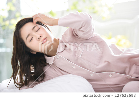 Young woman relaxing in pajamas Young woman relaxing in pajamas 127622698